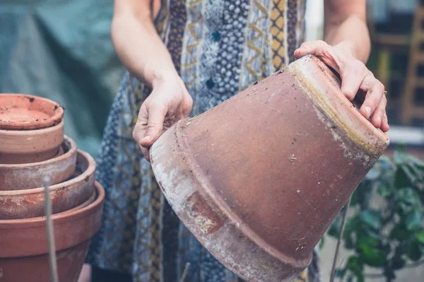 Mujer joven en el jardín con olla — Foto de Stock