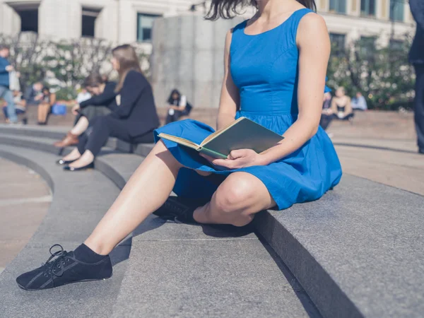 Junge Frau liest in der Stadt — Stockfoto