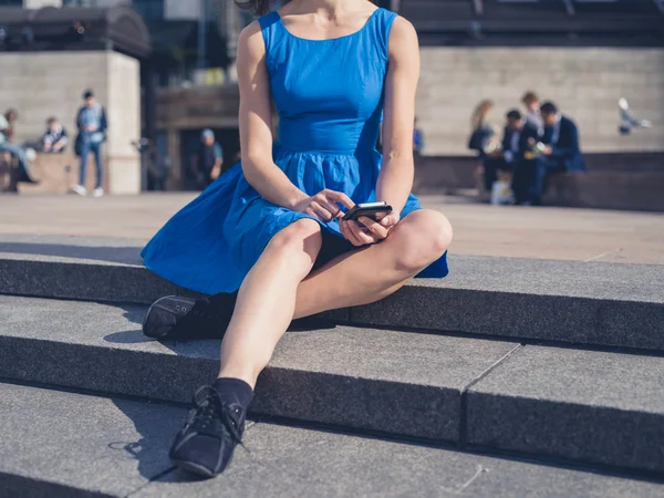 Молодая женщина использует свой смартфон в городе — стоковое фото