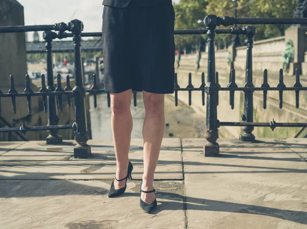 Legs of young businesswoman in city — Stock Photo, Image
