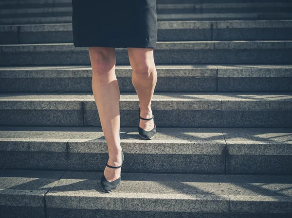 Benen van jonge zakenvrouw in stad op trappen — Stockfoto