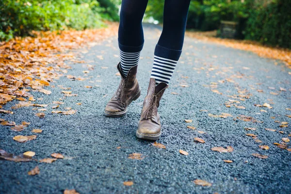 Ноги молодой женщины, идущей осенью — стоковое фото