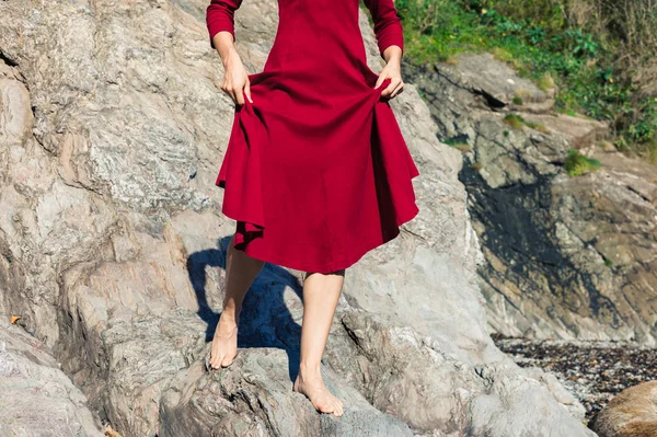 Donna in rosso che cammina sulle rocce — Foto Stock