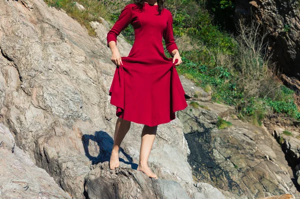 Mujer en rojo caminando sobre rocas — Foto de Stock