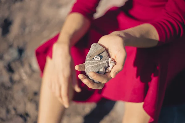 Mujer sentada en la playa con rocas — Foto de Stock