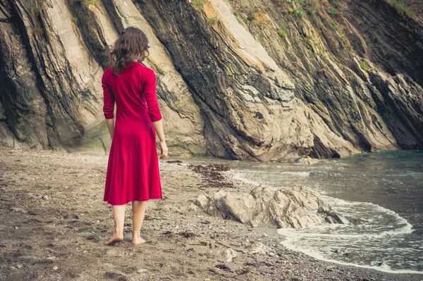 Junge Frau spaziert am Strand — Stockfoto