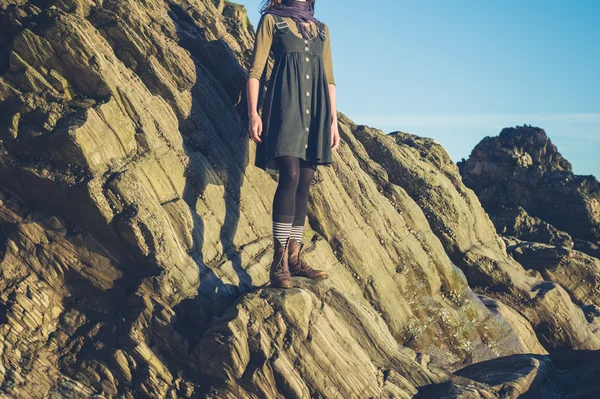 Junge Frau steht auf Felsen — Stockfoto