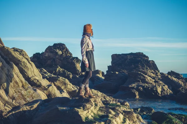 Frau mit Hut steht auf Felsen — Stockfoto