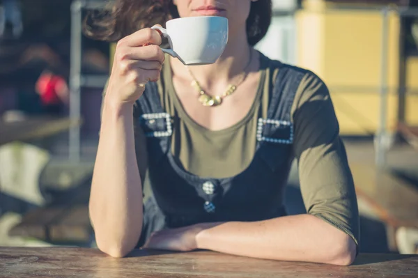 Jonge vrouw drinken koffie buiten — Stockfoto
