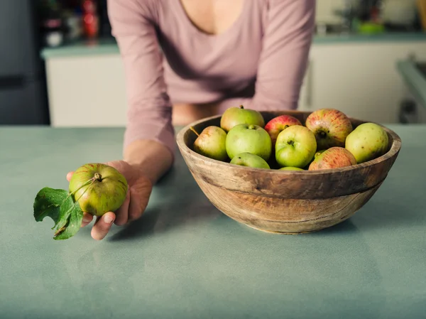 Young woman with apples in kitchen — Stock Photo, Image