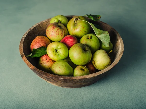 Cuenco de manzanas sobre mesa verde — Foto de Stock