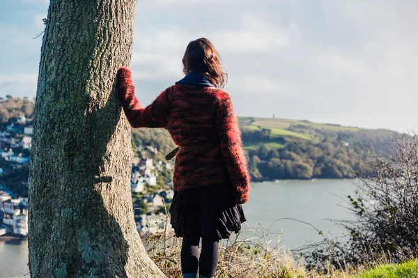 Ung kvinna vandring ovanför staden vid havet — Stockfoto