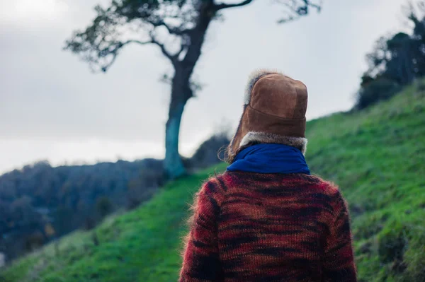 Jeune femme randonnée sur colline par arbre — Photo