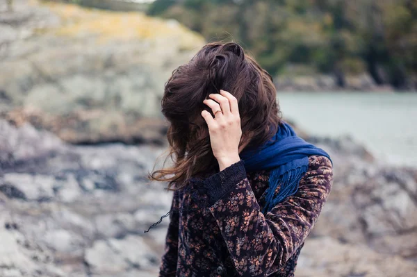 Giovane donna in piedi sulla costa in autunno — Foto Stock