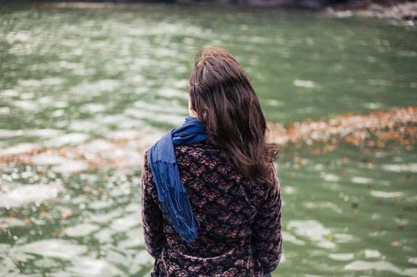 年轻的女人坐在大海边在秋天 — 图库照片