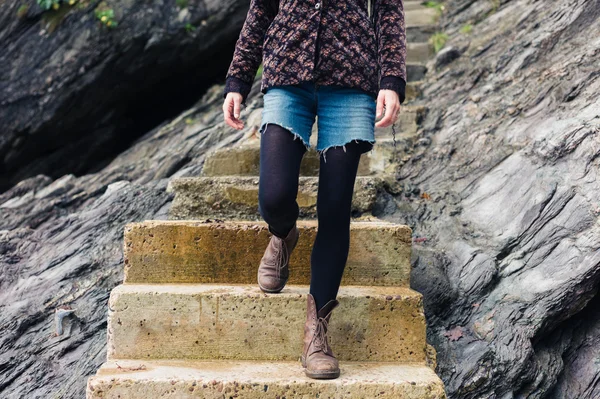 Jonge vrouw permanent over stappen in de natuur — Stockfoto