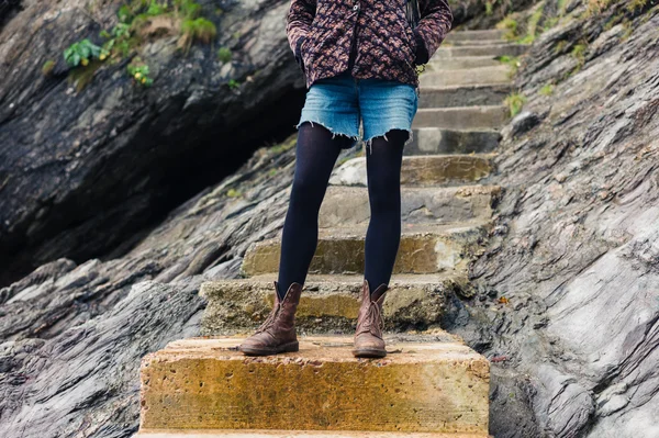 Mujer joven de pie en los escalones de la naturaleza — Foto de Stock