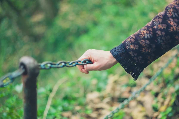 Vrouwelijke hand aanraken reling in bos — Stockfoto