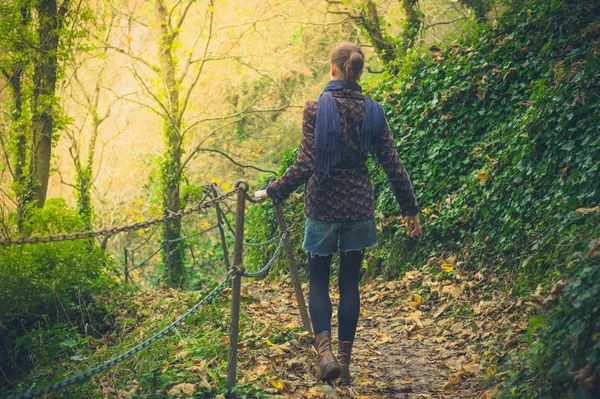 Ung kvinna promenader i skogen — Stockfoto