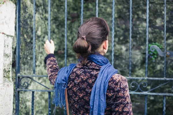Young woman standing outside some gates — Stock Photo, Image