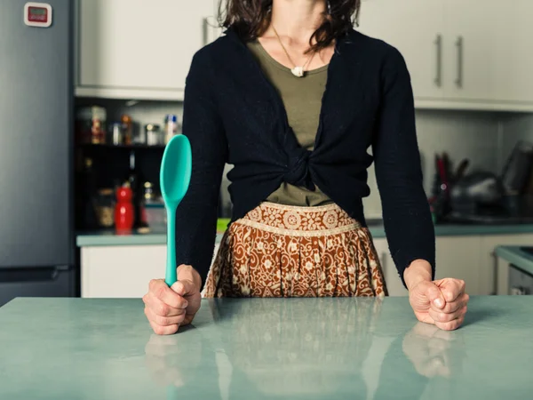 自信的女人，用勺子在厨房 — 图库照片