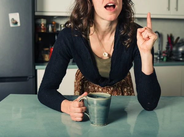 Jovem mulher recebendo ideia na cozinha — Fotografia de Stock