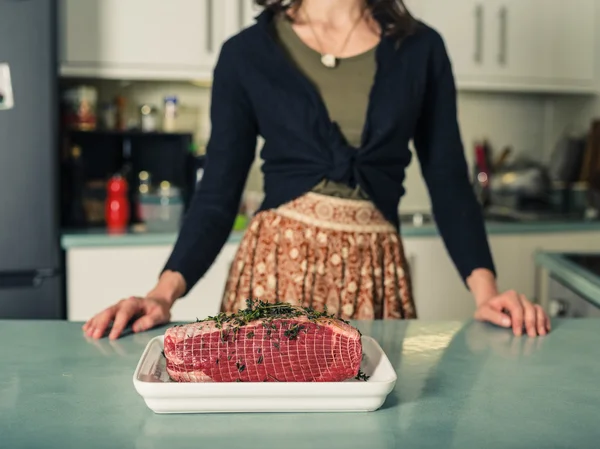 Mujer joven con asar conjunta en la cocina —  Fotos de Stock