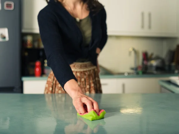 Genç bir kadın mutfağını temizliyor. — Stok fotoğraf
