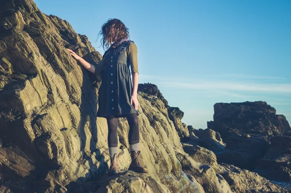 Jovem mulher de pé em um penhasco — Fotografia de Stock