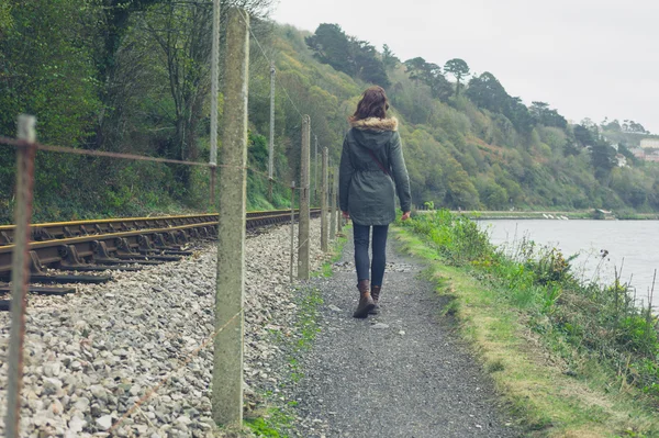 Mujer joven caminando por las vías del tren —  Fotos de Stock