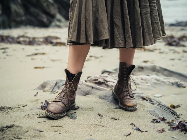 Füße einer jungen Frau mit Stiefeln am Strand — Stockfoto