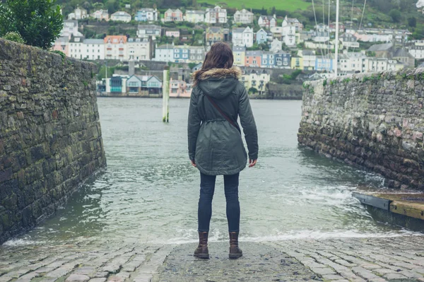 Young woman standing by water in village — Stock Photo, Image