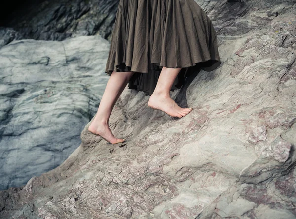 Barefoot woman climbing rock — Stock Photo, Image