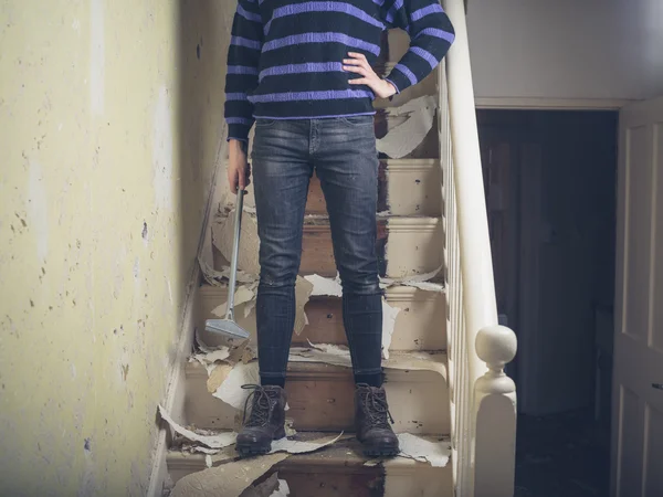 Woman stripping wallpaper on stairs — Stock Photo, Image