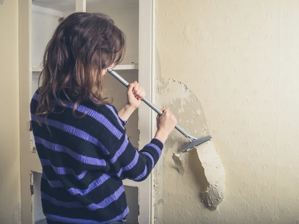 Woman stripping wallpaper — Stock Photo, Image