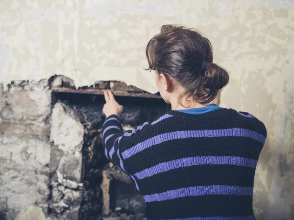 Young woman examinig fireplace — Stock Photo, Image