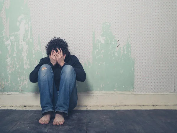 Triste jeune homme dans une pièce vide — Photo