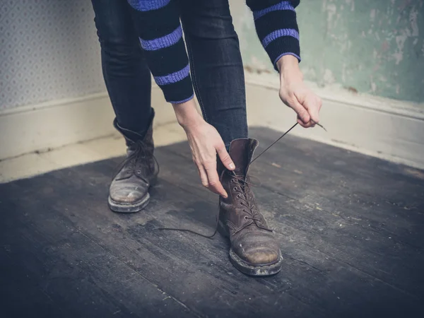 Jovem mulher amarrando suas botas — Fotografia de Stock