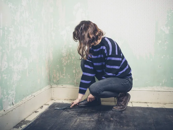 Woman prying nail with crowbar — Stock Photo, Image