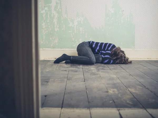 床に横たわる悲しい若い女 — ストック写真