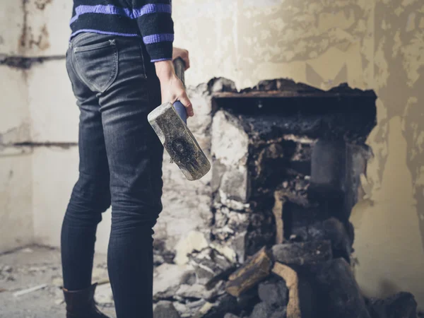 Woman opening up fireplace with sledge hammer — Stock Photo, Image