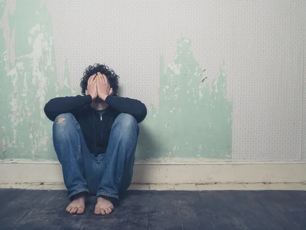 Sad young man in empty room — Stock Photo, Image