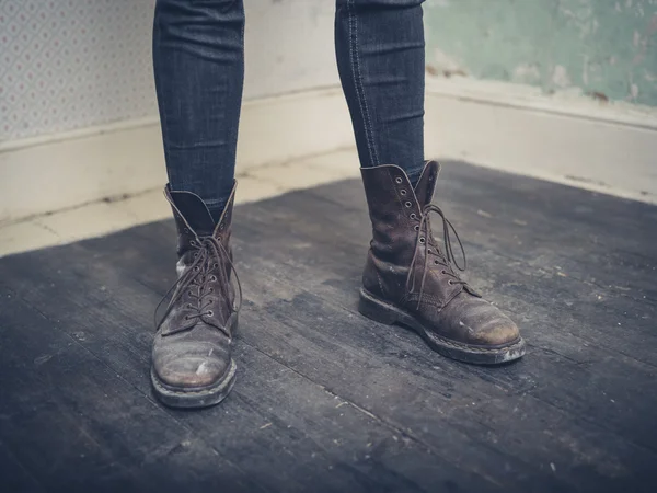 Pessoa usando botas de pé no quarto vazio — Fotografia de Stock