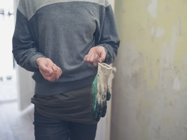 Молода жінка в коридорі з садовими рукавичками — стокове фото