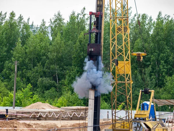 Drop hammer while working on driving piles, diesel hammer strikes a series of blows on a concrete pile, Foundation construction using iron concrete pile