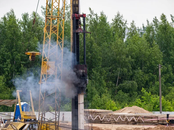 Drop hammer while working on driving piles, diesel hammer strikes a series of blows on a concrete pile, Foundation construction using iron concrete pile