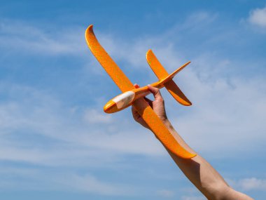 Oyuncak uçak, elinde planör açık mavi gökyüzüne karşı güneşli yaz havasında, açık havada dinlenme