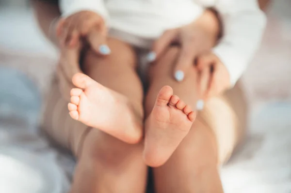 Baby legs in moms arms — Stock Photo, Image