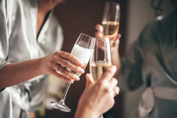 Brud med brudtärna med ett glas champagne i handen Royaltyfria Stockfoton