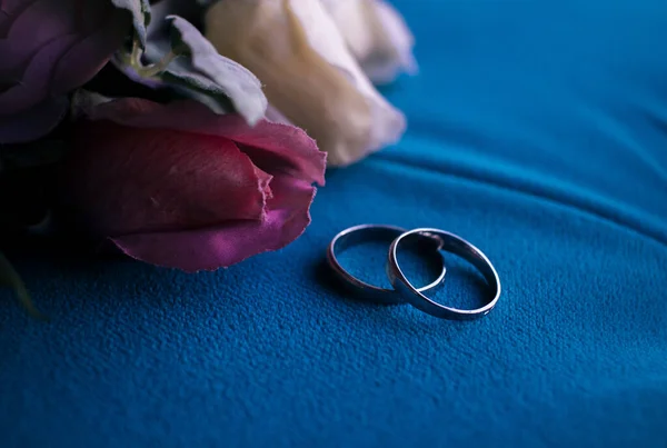Photo Wedding Rings Flowers Blue Fabric Close — Stock Photo, Image